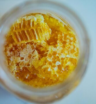 Close-up view of fresh honeycomb pieces in a jar, showcasing natural sweetness and texture.